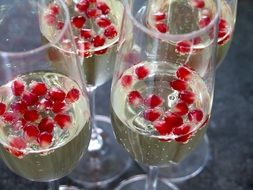 champagne glasses with red berries on the table