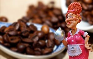 funny figurine of a cook on a background of coffee beans