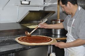 Guy is making the italian pizza
