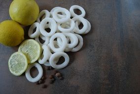 Fresh Squid Rings Lemon slices on wooden desk