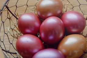 painted chicken eggs in a metal wicker basket