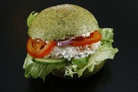 burger with spinach bread on black