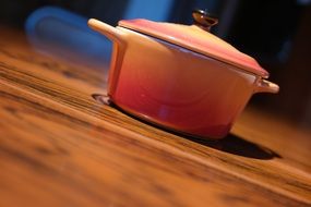 Orange cooking sauce pan on the floor