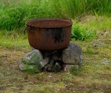 rusty cooking pot on stones for outdoor cooking