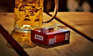 mug of beer and cigarettes on a wooden table