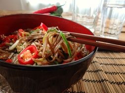 Eating vegetable noodles with the chopsticks