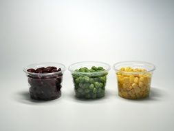 three plastic cups with multicolored beans