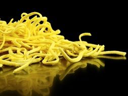 egg noodles on a black background