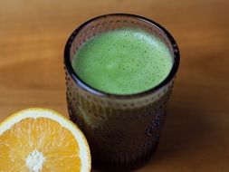 Green Smoothie in glass and piece of lemon