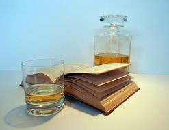 carafe with whiskey and opened book