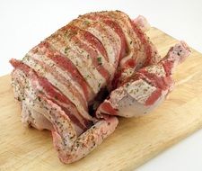 Bloody bacon on a wooden board