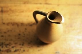 wooden Jug on table closeup on a blurred background