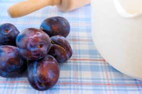 blue plums and rolling pin on the table