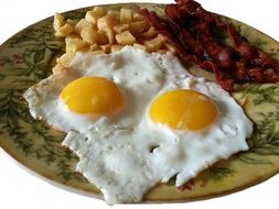 baked Eggs with bacon and potatoes on plate