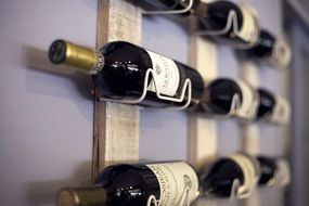 bottles of red wine on a wall bracket