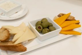 Cheddar, Brie, Swiss Cheeses and olives on board