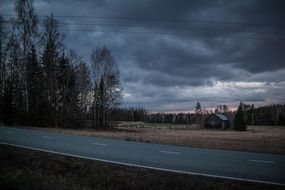 distant view of a barn near the highway at dusk