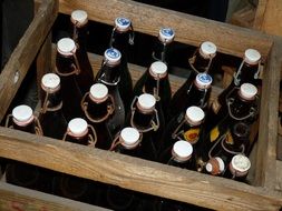 glass bottles with a drink in a wooden box