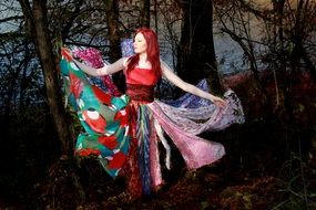 girl in a multi-colored dress in a dark forest