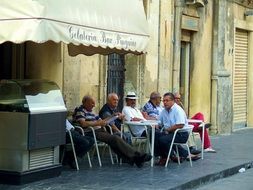 People are sitting near the cafe in Italy