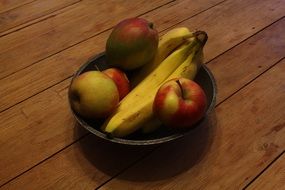 Bananas and red apples in the bowl