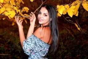 long haired brunette Girl in forest among the colorful leaves in autumn