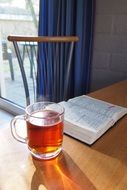 cup of tea near the open bible on the table