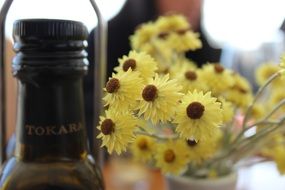 bottle of wine Tokara and yellow flowers in a vase