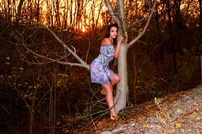 photo of a girl in a blue dress by a tree