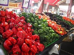 colorful peppers, tomatoes, cucumbers and greens on the market