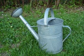 big watering can on green grass