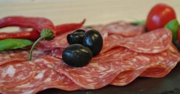 salami slices on a plate with olives
