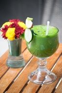 flowers and green drink in a glass in a coffee shop