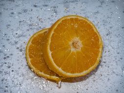 Sweet sliced orange in drops of water