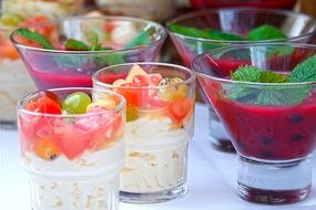 fruit desserts with berries and mint in glasses close-up