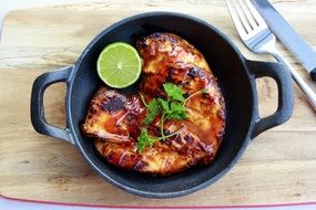 Grilled chicken and a lime in a pan