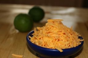 yellow cheddar cheese grated in a plate