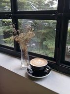 cup with aromatic coffee on the windowsill