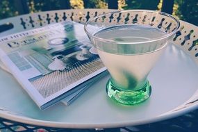 glass with martini and magazine