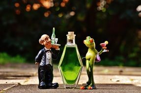 funny figurines and bottle with green beverage