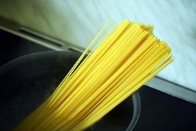 cooking the yellow spaghetti in the pan