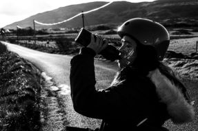 Black and white photo of a cyclist who drinks water