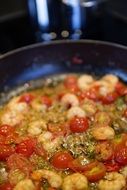 shrimp with tomatoes in a pan close-up