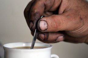a man mixes coffee with a spoon