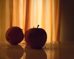 apples on a table in a dark kitchen