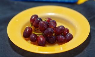 Red grapes in a yellow plate