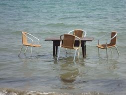 Table and chairs in water at Beach, Greece, Corfu