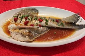 white fish with sauce on a white plate
