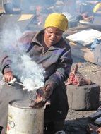 dark skin woman Cooking goat heads outdoor, South Africa