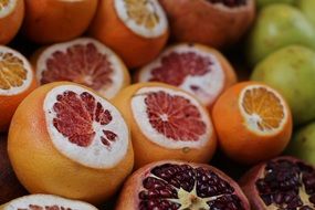 grapefruit, orange and pomegranate with cut-off hats